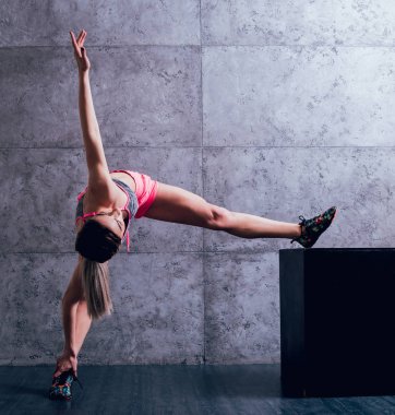 Studio poz ve farklı egzersizleri yapıyor genç atletik beyaz kadın.