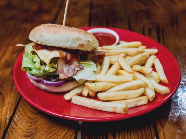 Büyük çizburger ve patates kızartması bir plaka üzerinde. Restoran