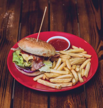 Büyük çizburger ve patates kızartması bir plaka üzerinde. Restoran