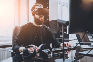 Sanal gerçeklik giyen sakallı genç adam ofiste gözlükler