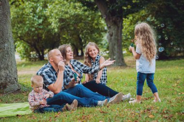 Büyük genç aile parkta iyi vakit geçiriyor.