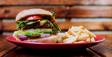 Büyük çizburger ve patates kızartması bir plaka üzerinde. Restoran