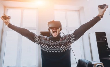 Mutlu genç adam ofiste bir oyun oynuyor. Sanal gerçeklik kulaklık.