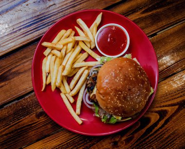 Büyük çizburger ve patates kızartması bir plaka üzerinde. Restoran