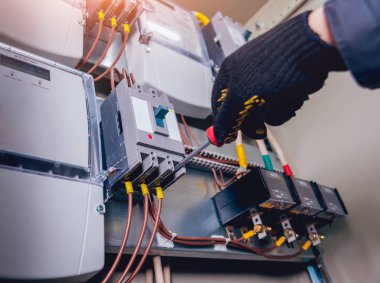 Elektrik kutusuna anahtarları test elektrikçiler eller. Sigortalar ve Kontaktörler elektrik paneli.