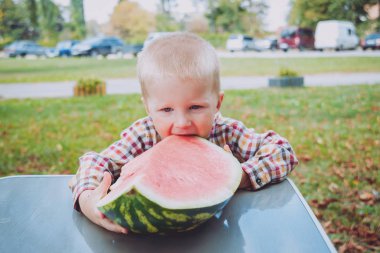 Küçük çocuk yeşil yaz parkta karpuz yeme