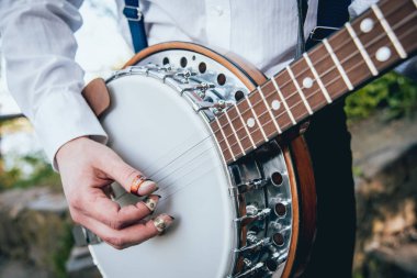 Müzisyen banjo sokakta oynarken görüntü kırpılmış