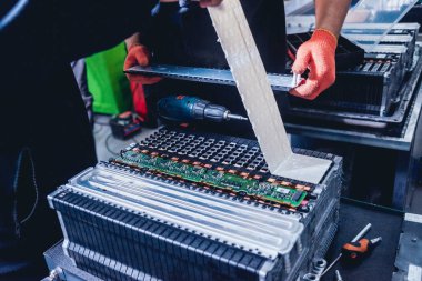 Elecric motorlu pilleri şarj. Pil bir elektrikli araç motorunun sökülmesi. Araba Servisi