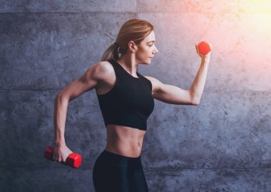 Studio poz ve farklı egzersizleri yapıyor genç atletik beyaz kadın.