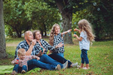 Büyük genç aile parkta iyi vakit geçiriyor.