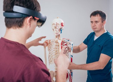 Doktor kullanır augmented gerçeklik gözlükleri ve öğrenci öğretim insan iskeleti