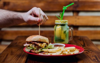 Büyük çizburger ve patates kızartması bir plaka üzerinde. Restoran