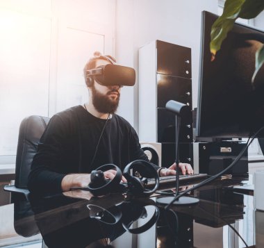 Sanal gerçeklik giyen sakallı genç adam ofiste gözlükler