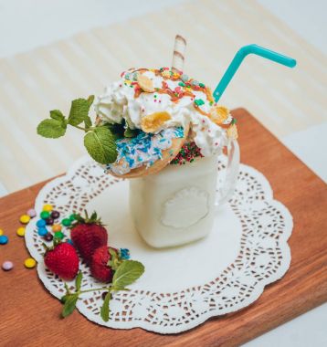 İle sprinkles, çilekli milkshake bardak çırpılmış krema ve taze çilek