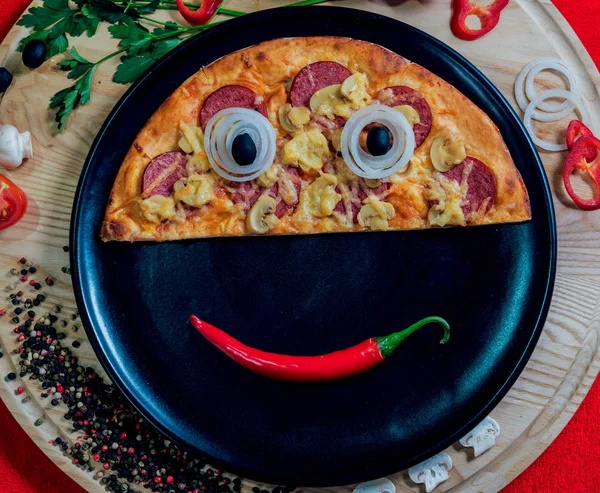 Funny pizza face on black plate