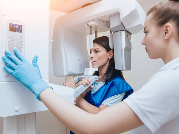 Young woman patient standing in x-ray machine. Panoramic radiography