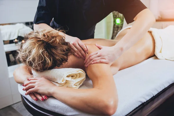 Cropped image of woman relaxing in the spa. Body massage.