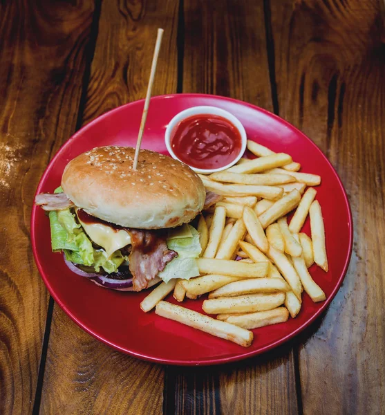 Big cheeseburger and chips on a plate. Restaurant