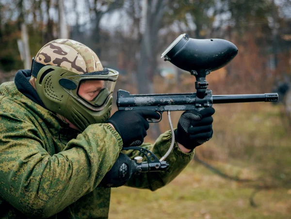 Paintball oynarken silahlı adam. Açık havada.
