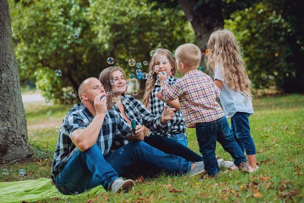 Büyük genç aile parkta iyi vakit geçiriyor.