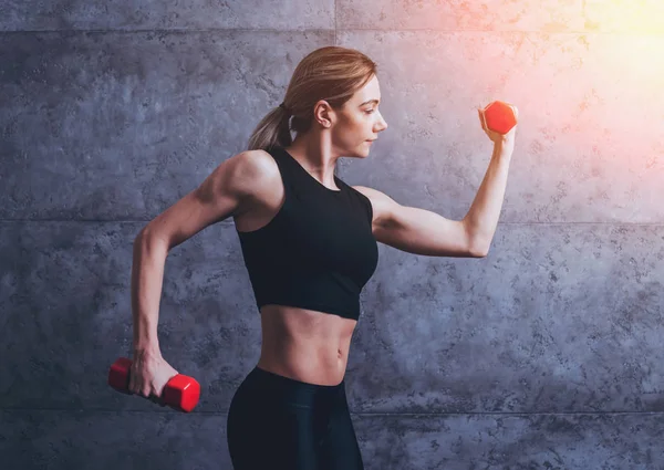 Studio poz ve farklı egzersizleri yapıyor genç atletik beyaz kadın.