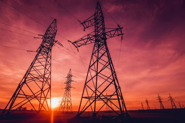 High-voltage power lines at sunset. Electricity distribution station.