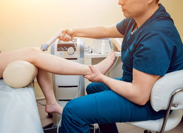Shock wave therapy. The magnetic field, rehabilitation. Physiotherapist doctor performs surgery on a patients knee — Stock Image Shock Wave Therapy Magnetic Field Rehabilitation Physiotherapist Doctor Performs Surgery Stock Picture