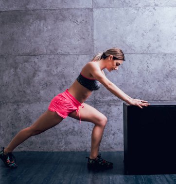 Studio poz ve farklı egzersizleri yapıyor genç atletik beyaz kadın.