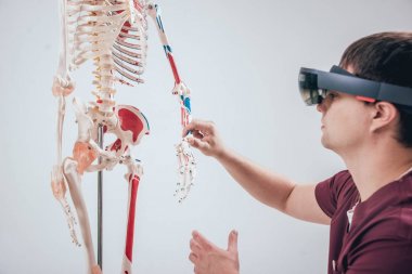 Doktor insan iskeletini incelemek için artırılmış gerçeklik gözlüğü kullanıyor.