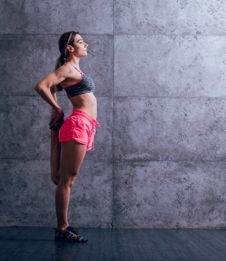 Studio poz ve farklı egzersizleri yapıyor genç atletik beyaz kadın.