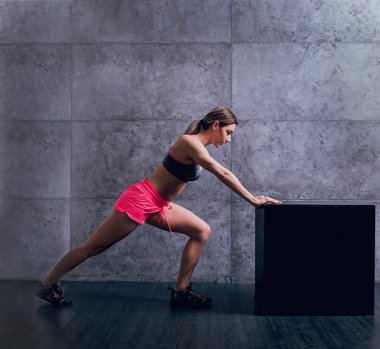 Studio poz ve farklı egzersizleri yapıyor genç atletik beyaz kadın.