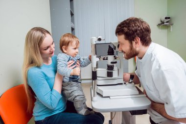 Lamba muayene kesti. Biomicroscopy anterior göz parçasının. Temel göz muayenesinde. Anne Çocuk göz muayenesi sırasında tutar..