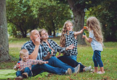 Büyük genç aile parkta iyi vakit geçiriyor.
