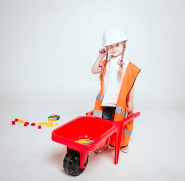 Onarım veya inşaat oynarken örgüler ile küçük neşeli kız