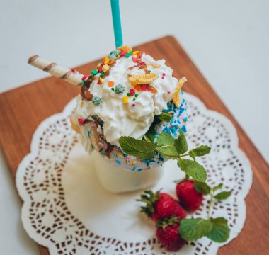 İle sprinkles, çilekli milkshake bardak çırpılmış krema ve taze çilek