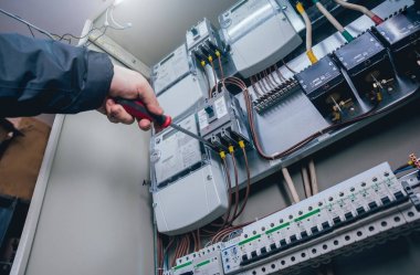 Elektrik kutusuna anahtarları test elektrikçiler eller. Sigortalar ve Kontaktörler elektrik paneli.
