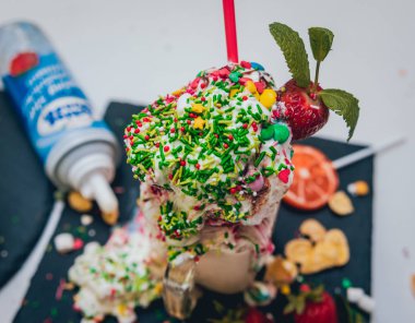 İle sprinkles, çilekli milkshake bardak çırpılmış krema ve taze çilek
