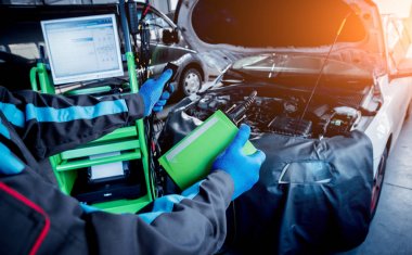 Otomatik onarım hizmetinde çalışan profesyonel araba tamircisi. Motor bilgisayar tanılama