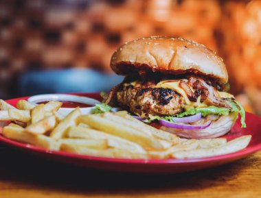 Büyük çizburger ve patates kızartması bir plaka üzerinde. Restoran