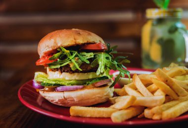 Büyük çizburger ve patates kızartması bir plaka üzerinde. Restoran