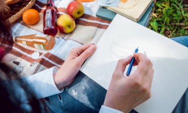 Parkta piknik sırasında Sketchbook içinde çizim kız