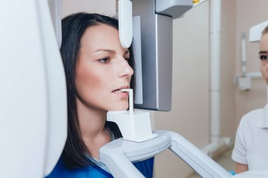 X-ray makinesi hasta kalan genç kadın. Panoramik Radyografi