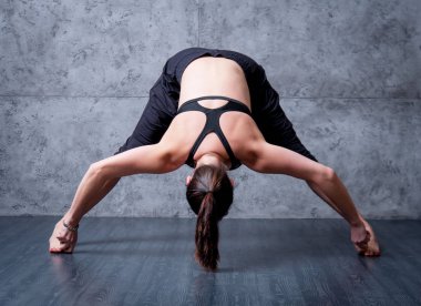 Gri duvar Yoga pratik kadın.