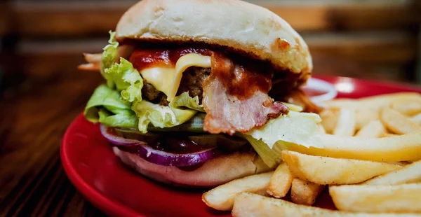 Büyük çizburger ve patates kızartması bir plaka üzerinde. Restoran