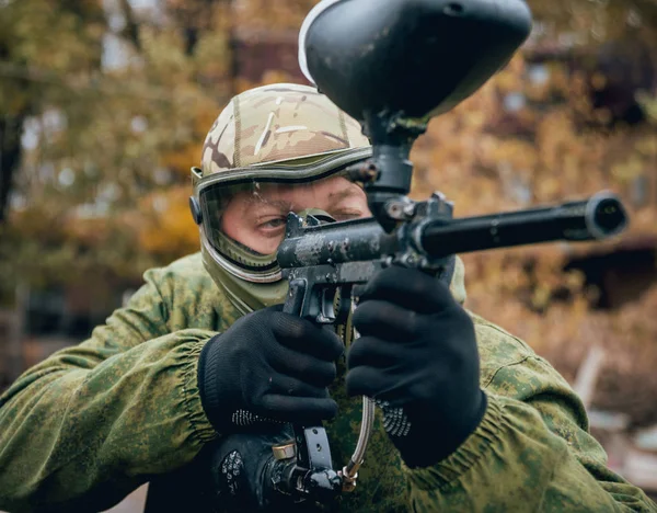 Paintball oynarken silahlı adam. Açık havada.