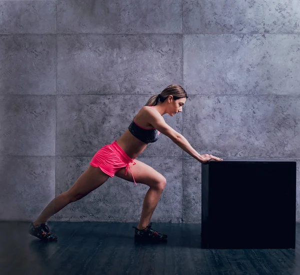 Studio poz ve farklı egzersizleri yapıyor genç atletik beyaz kadın.