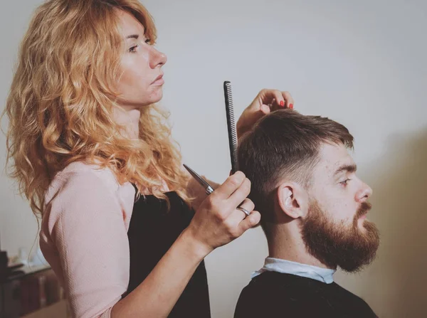 若い男の美容師が髪型を作るマスター カット髪と男性のひげ — ストック写真