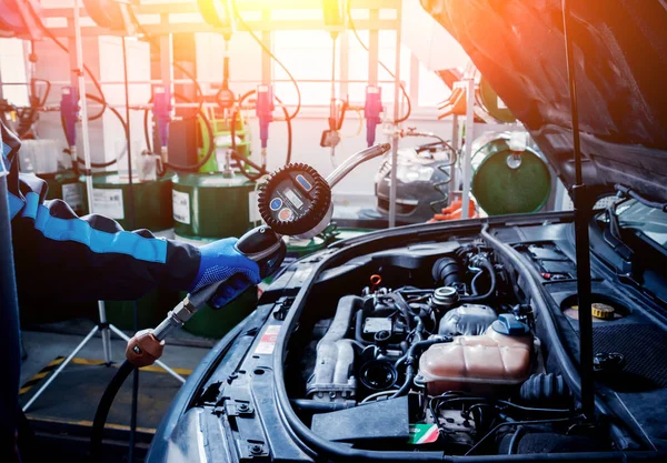 Male hands changing engine oil in car