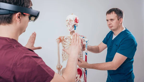 医生使用增强现实护目镜和人体骨架教学学生 — 图库照片