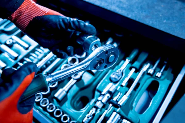 Tools at the hands. Auto repair service.